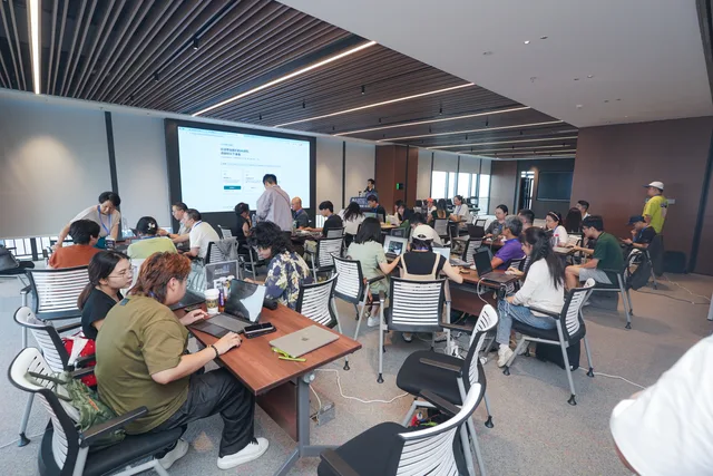 學員分組使用手提電腦，並在課桌旁互相交流
