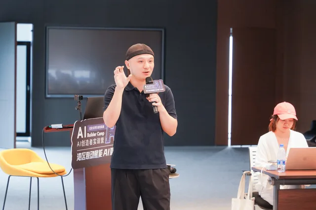 講者在課室前方手持咪高峰，以手勢輔助講解